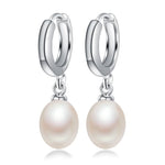 Elegant sterling silver dangle earrings adorned with lustrous freshwater pearls, a sophisticated accessory for any occasion.