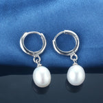 Elegant sterling silver dangle earrings featuring natural freshwater pearls, perfect for any occasion.