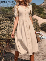 Elegant beige midi dress with a v-neck, button-down closure, and short puff sleeves, worn by a woman holding a basket of flowers in a scenic outdoor setting.