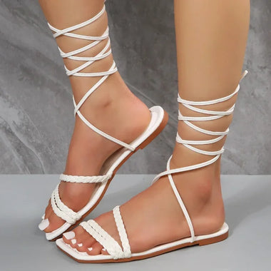 Sleek summer sandals with crisscross straps, open toe design, and a flat sole for comfortable wear on the beach or around town.