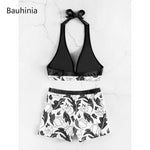 Elegant black and white floral print halter two-piece swimsuit from Laneberg, featuring a V-neck bikini top and high-waisted shorts for a stylish summer look.