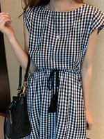 Stylish gingham dress with short sleeves, cinched waist, and tie detail for a casual yet chic summer look.