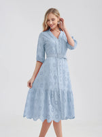 Elegant blue cotton summer dress with intricate floral eyelet embroidery and a flattering A-line silhouette. The dress features a belted waist, V-neck, and three-quarter length sleeves, creating a chic and feminine look for warm weather occasions.