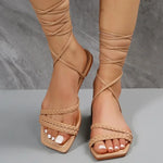 Elegant flat sandals with criss-cross lace-up design, perfect for summer beach style.