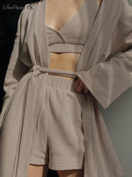 Beige waffle texture three-piece loungewear set with a lace-up blouse, wide-leg shorts, and a matching robe, showcasing a modern and comfortable homewear style.