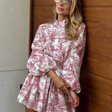 Elegant floral print mini dress with puff sleeves, stand collar, and lace-up detail, showcased by a stylish woman in front of a building.